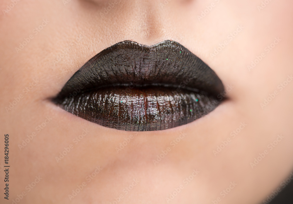 Naklejka premium Lips painted with black lipstick