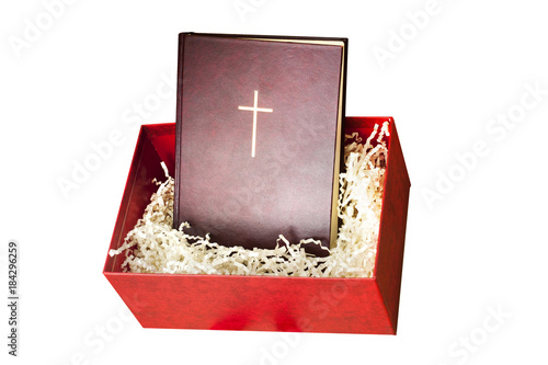 Red bibile in the gift box with paper filling on white background.  photo