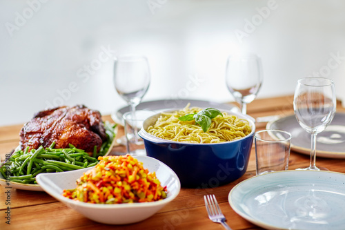 pasta with basil in bowl and other food on table