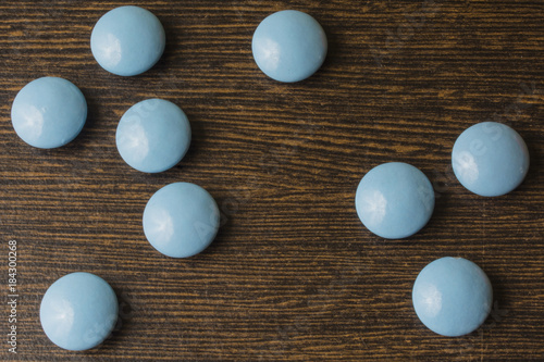 Heap of blue pills capsule on wooden table photo