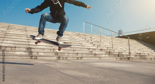 Skateboarder jumping on city stairs with skateboard
