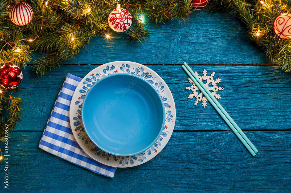 Photo of New Year branches of fir, cookies with prediction, plates, sticks for sushi, snowflakes, napkin Photo of New Year branches of fir, cookies with prediction, plates, sticks for sushi, snowflakes, napkin