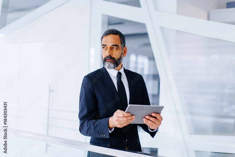 Middle age businessman with tablet in the office Middle age businessman with tablet in the office