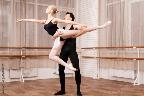 Man and woman dancers posing in ballet class.