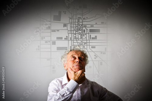 Old man is looking for a route on the city map.