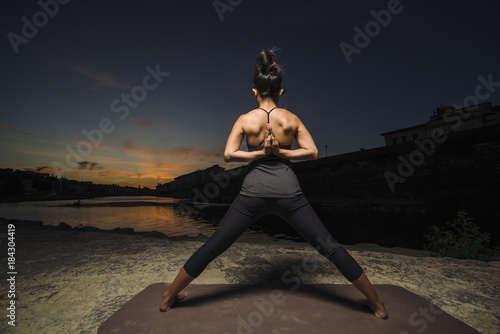 Woman practicing yoga near a river