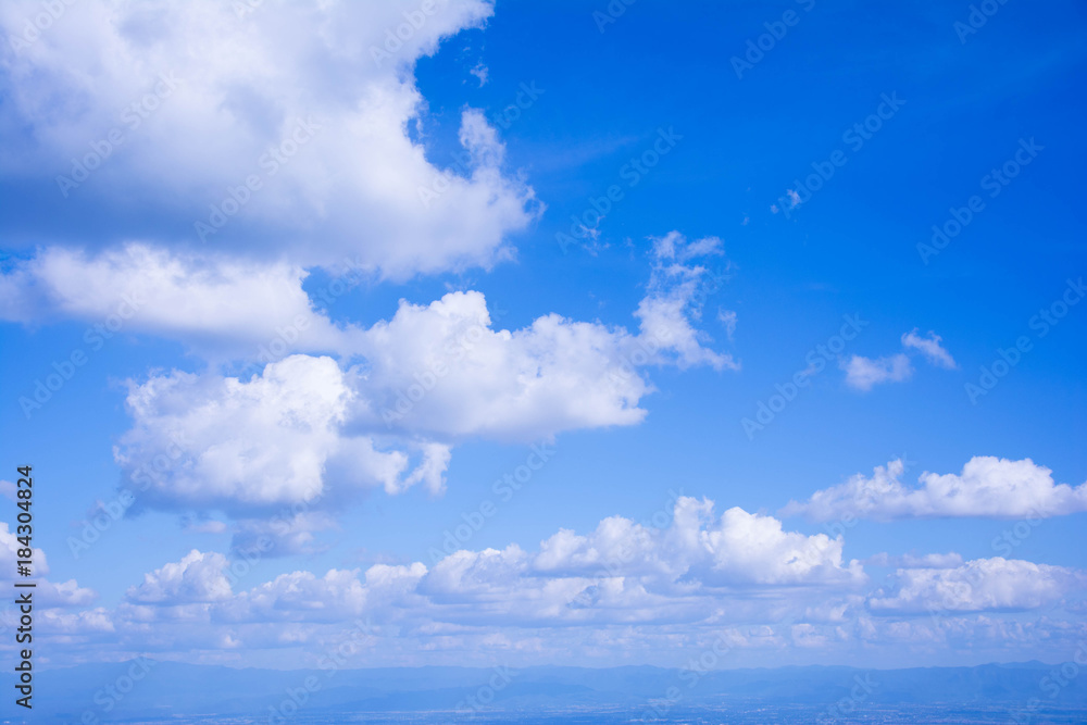 The white cloud on the blue sky in the bright day is suitable for being the nice background from the view of the highest point of Thailand. There are mountains being far at the below of the pic.