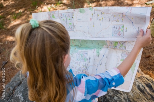 Girl reading the map in the forest photo