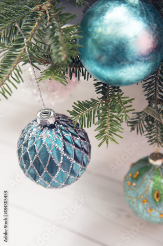 Blue baubles hanging on fir tree branches