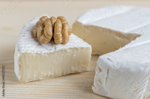 camembert and walnut on wooden background