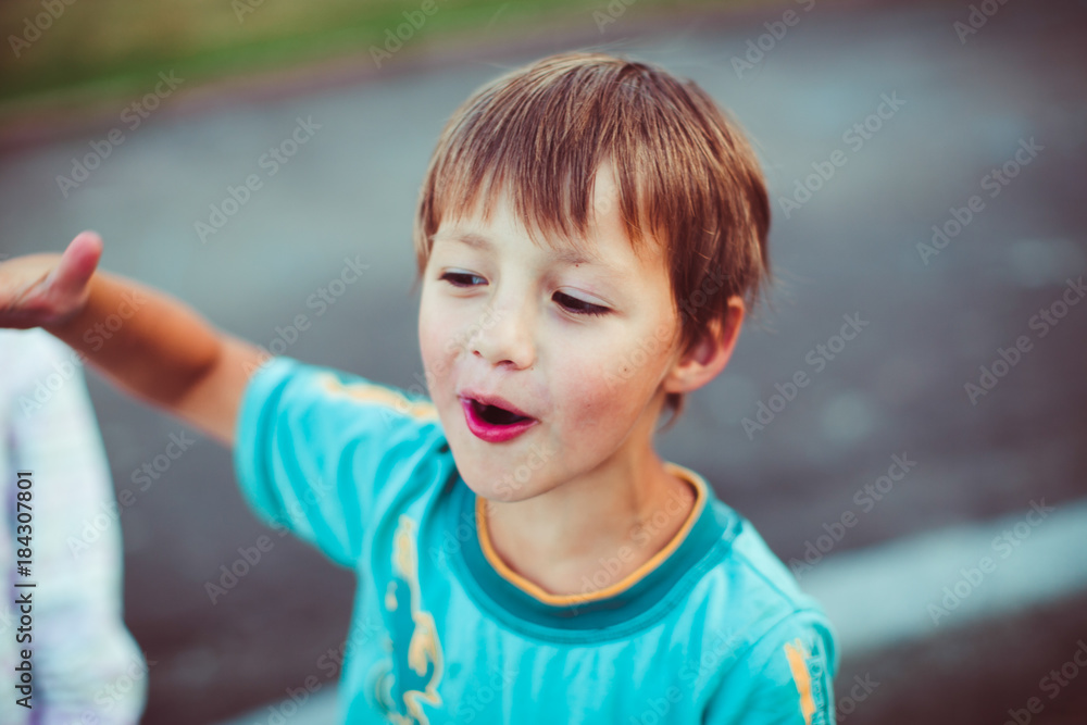 Happy little boy stands outside on the street Happy little boy stands outside on the street