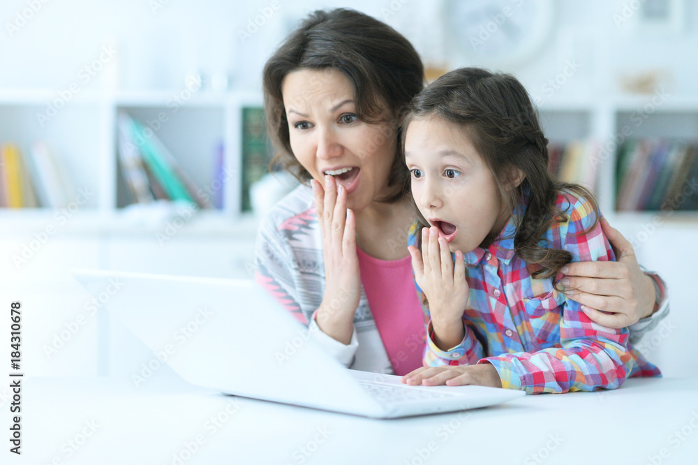 mother and daughter using laptop mother and daughter using laptop