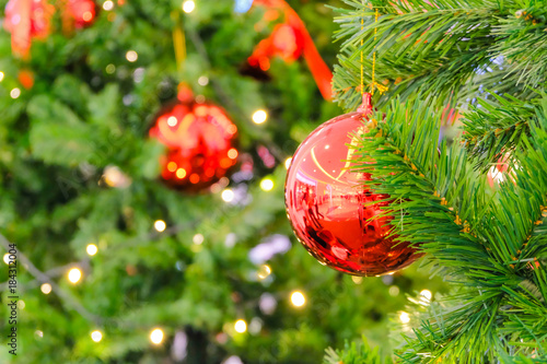 Soft focus of red chrismas ball on fake christmas tree and blurry backgroung
