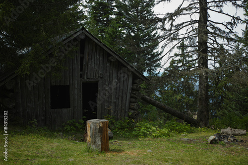 Old wooden mountain hut refuge for hikers, protect against bad weather conditions photo