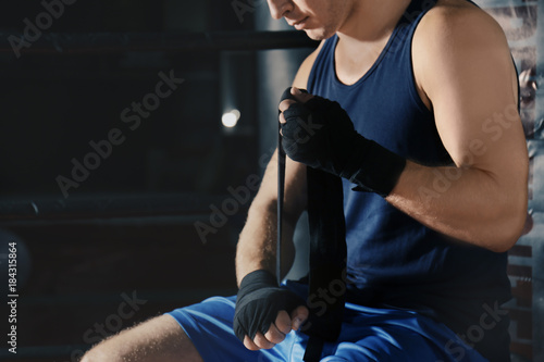Male boxer applying hand wraps while preparing for training in gym © Africa Studio