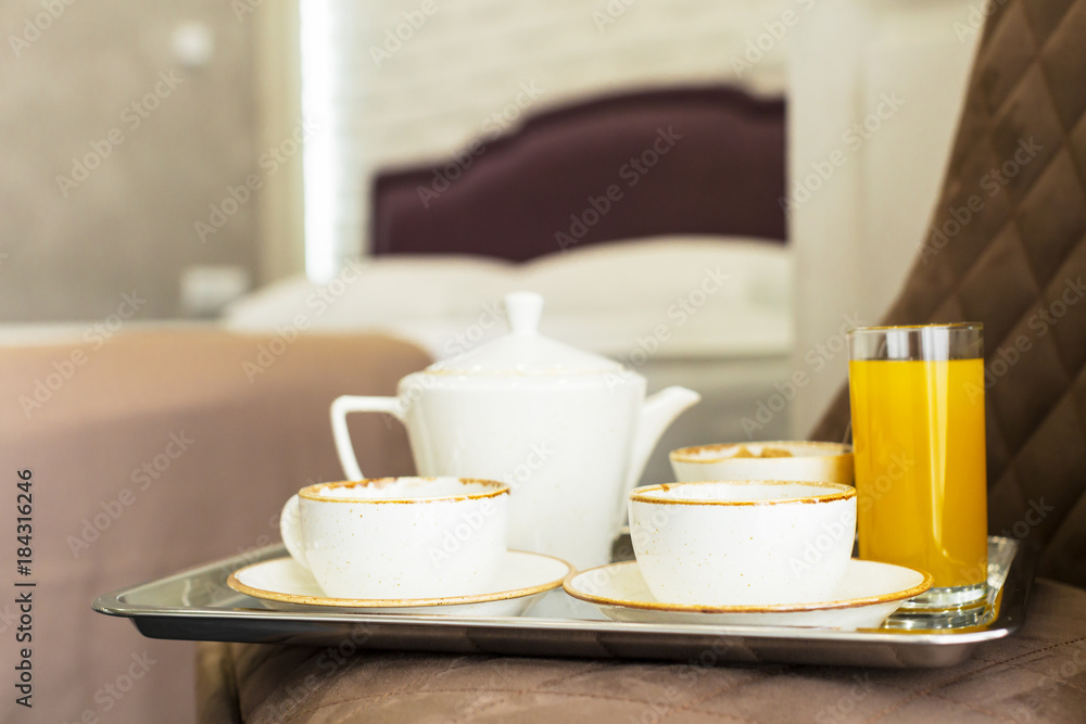 Two white mugs on a tray white bed, breakfast concept