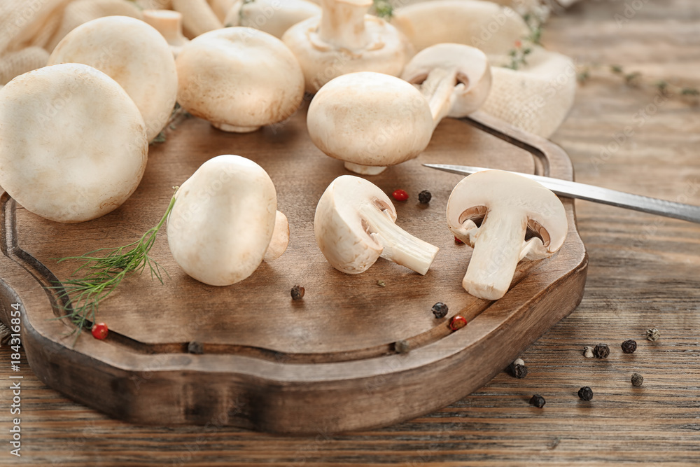 Fresh champignon mushrooms on wooden board Fresh champignon mushrooms on wooden board