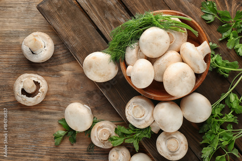 Fresh champignon mushrooms on wooden table