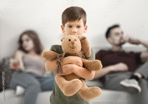 Upset little boy hugging to...