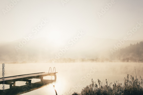 Fototapeta Naklejka Na Ścianę i Meble -  Mysterious lake on an early winter morning photographed in backlight in central Slovenia