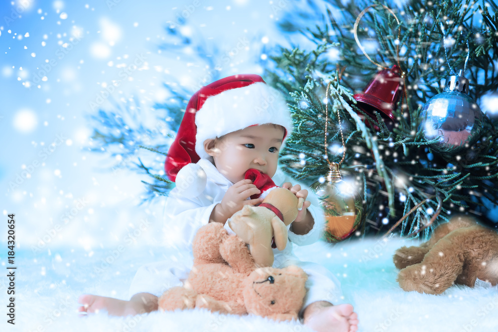 Portrait of asian baby girl wear santa hat with bear doll,Thailand people Portrait of asian baby girl wear santa hat with bear doll,Thailand people