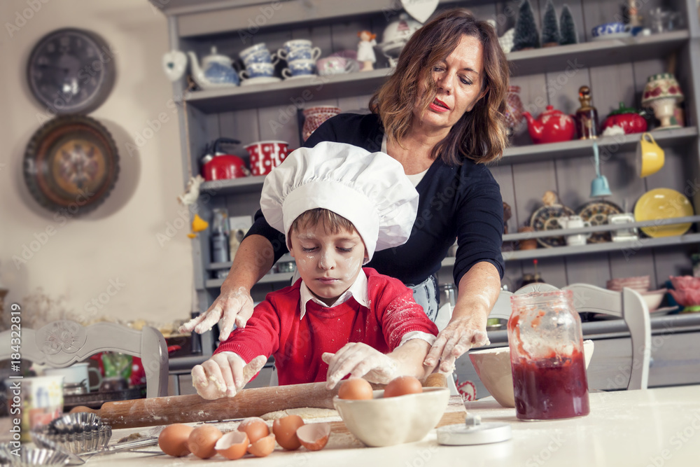 mom helping her son prepare sweet food mom helping her son prepare sweet food