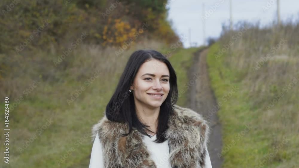Portrait of pretty brunette walks at forest and looks at camera Portrait of pretty brunette walks at forest and looks at camera