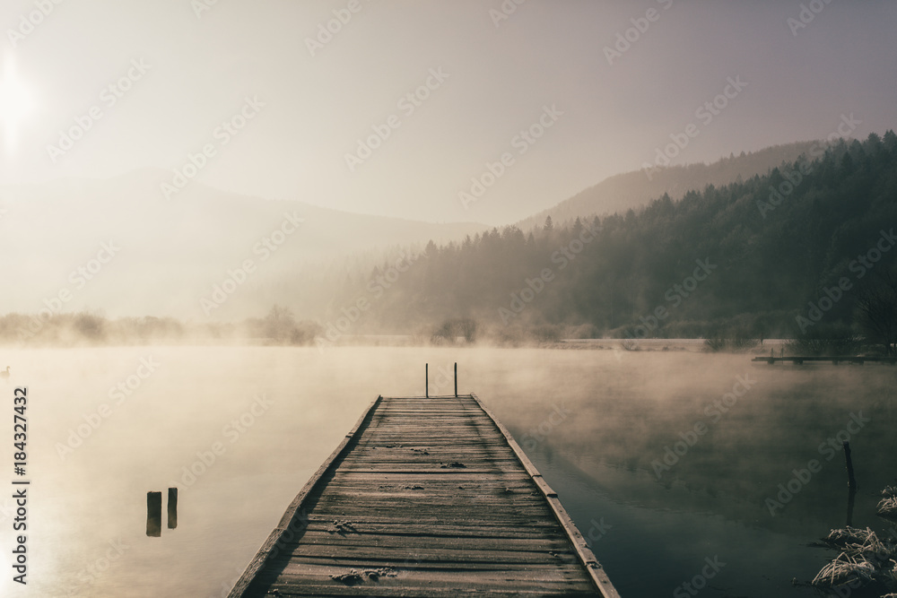 Mysterious lake on an early winter morning photographed in backlight in central Slovenia