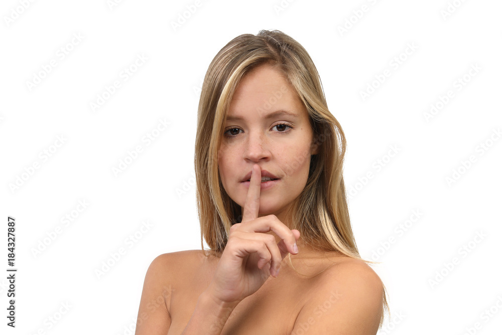 Hübsche blonde Frau mit nackten Schultern hält einen Finger vor die Lippen Hübsche blonde Frau mit nackten Schultern hält einen Finger vor die Lippen