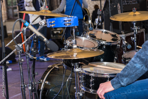 Drum set with drummer on a stage, preparation for the performance