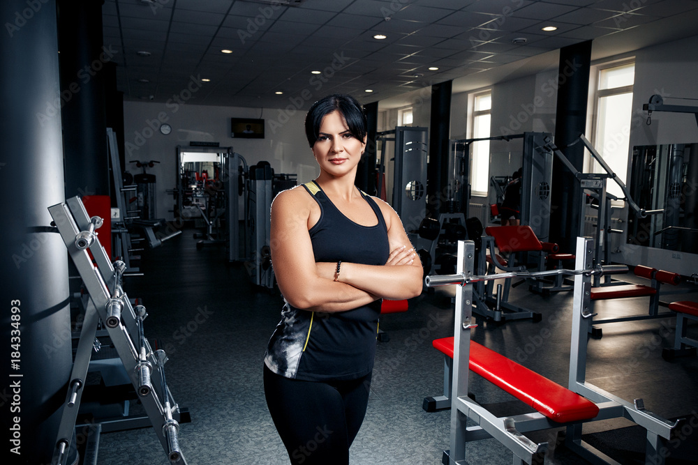 Woman plus size in gym posing happy, female XXL losing weight, fat