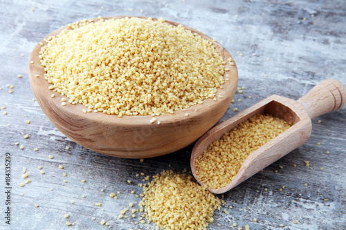 couscous in wooden spoon and couscous wooden bowl. photo