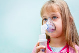 Portrait of sweet little girl using an inhaler