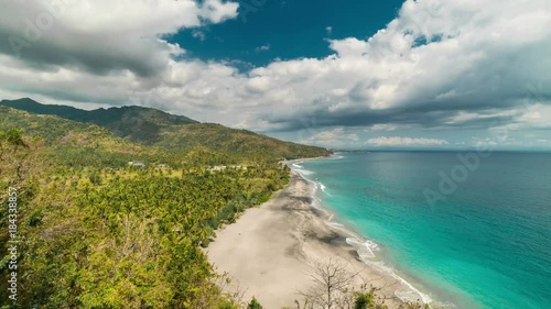 Timelapse Tropical sandy beach with palm trees at sunny day at the Lombok island, Indonesia photo