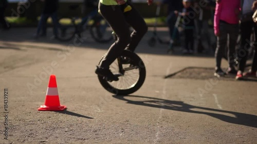 Outdoor portrait of young girl riding a unicycle one wheel bike on natural background. photo