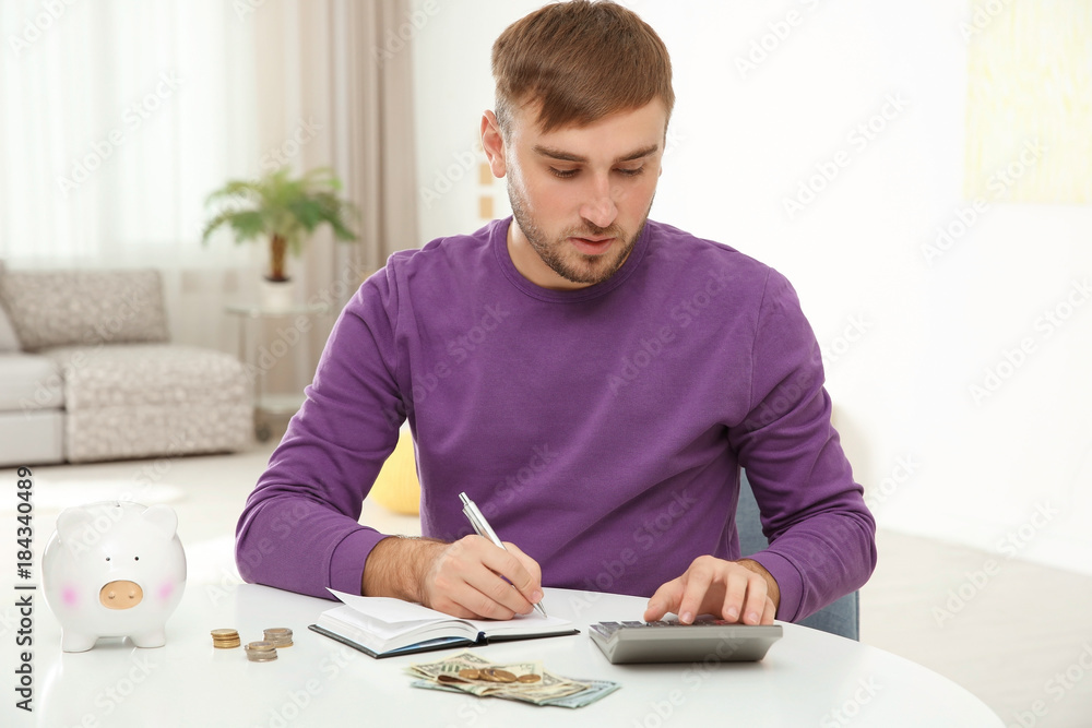 Man counting taxes at table indoors Man counting taxes at table indoors