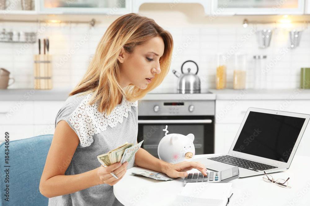 Woman counting taxes at table indoors Woman counting taxes at table indoors