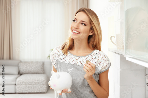 Young woman putting coin in...