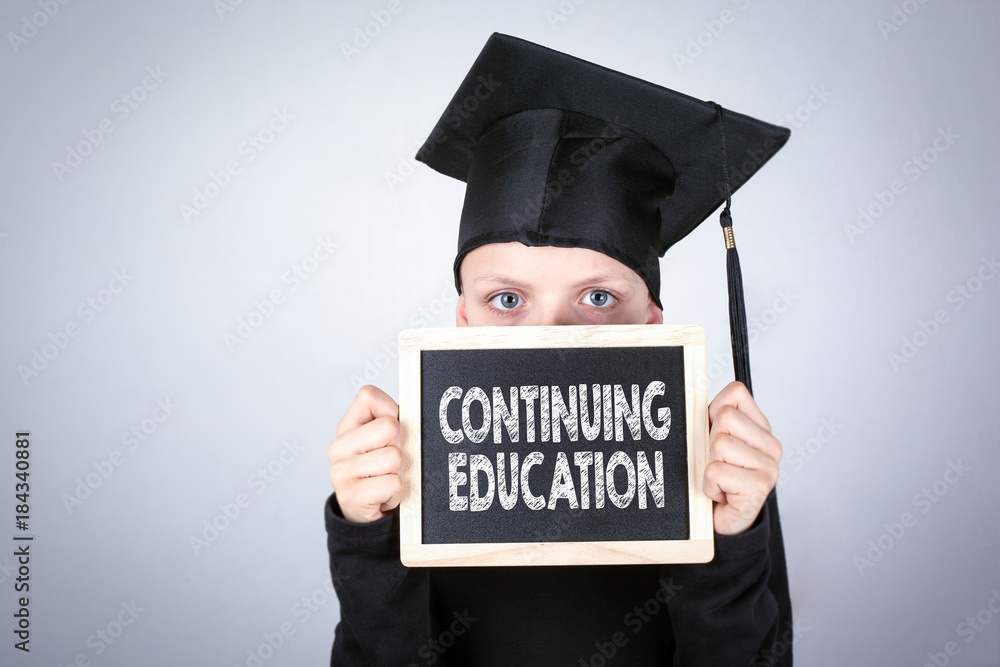 Continuing Education. Boy with a Chalkboard in hands. Knowledge, education and a successful career background. Continuing Education. Boy with a Chalkboard in hands. Knowledge, education and a successful career background.