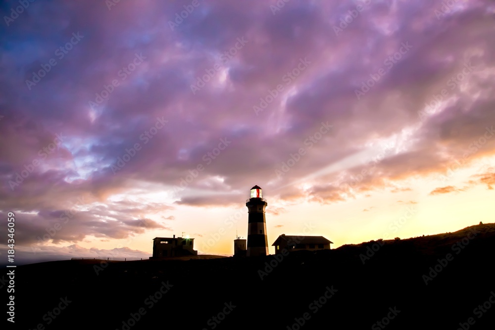 Lighthouse and Cloudy Sky at Sunset