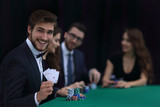 smiling business man showing four aces