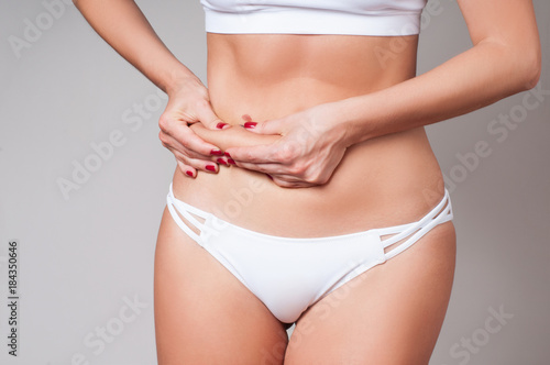 Fat female belly, woman holding her skin for cellulite check. © Dmytro Flisak