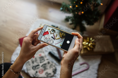 Concept of Christmas items. Woman's hands taking a photo.