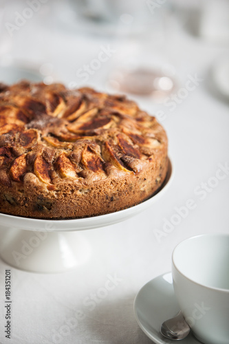 Fresh homemade apple cake on a laid table with white table cloth