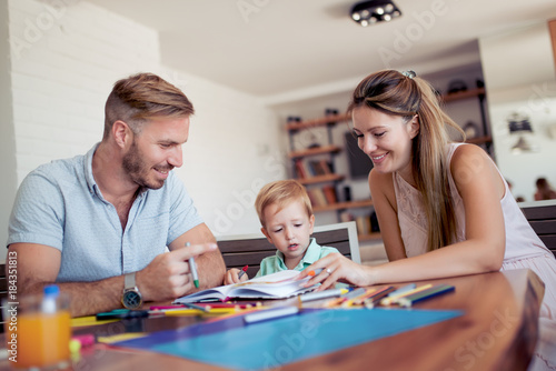 Mother and father drawing together with their child.