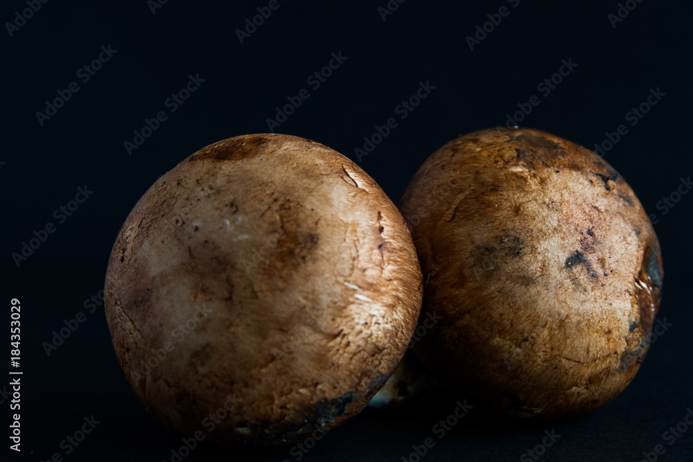 Fototapeta premium Close-up of fresh brown mushrooms isolated over black background