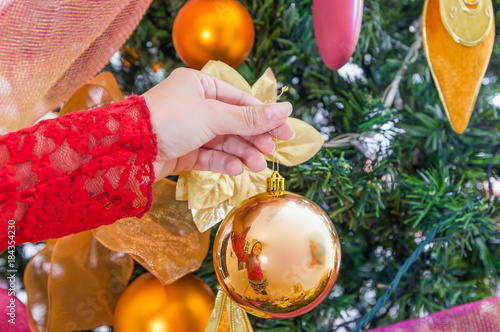 Close up of woman hand holding a christmas ball decorating a christmas tree, merry christmast and happy new year concept