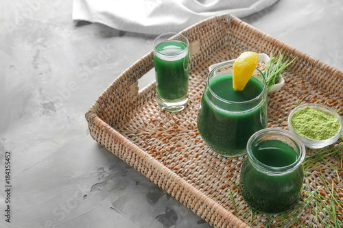 Glasses of wheat grass juice on wicker tray