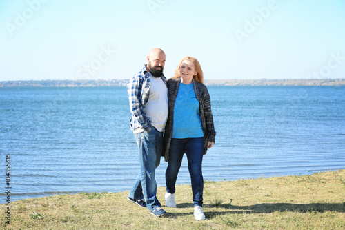 Overweight couple near rive...