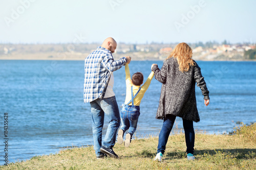 Overweight couple with son walking near river on sunny day © Africa Studio